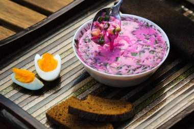 Süslü tepside yumurta ve ekmek ile soğuk pancar çorbası. Alışılmadık bir tepside kholodnik çorbası. Yiyecek..