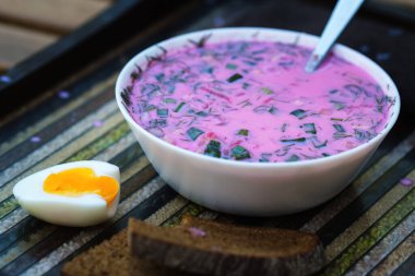 Süslü tepside yumurta ve ekmek ile soğuk pancar çorbası. Alışılmadık bir tepside kholodnik çorbası. Yiyecek..