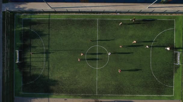 Vista superior de um campo de futebol esportivo com pessoas jogando soccer.a pequeno campo de futebol na rua no distrito de Serebryanka. — Vídeo de Stock