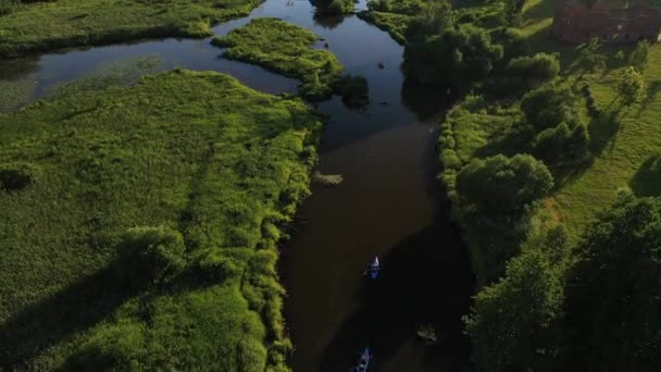 Vista superior de los kayakistas del río Svisloch flotando en el río en las ciudades Loshitsky Park al atardecer.La gente se relaja flotando en el río en kayaks.Beautiful naturaleza de Bielorrusia . — Vídeos de Stock
