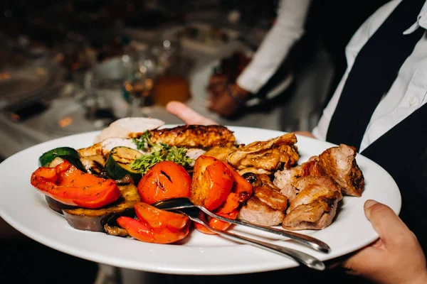 Večer podává restaurace na talíři v restauraci teplou mísu s grilováním se zeleninou.smažené maso s rajčaty a další zeleninou. — Stock fotografie