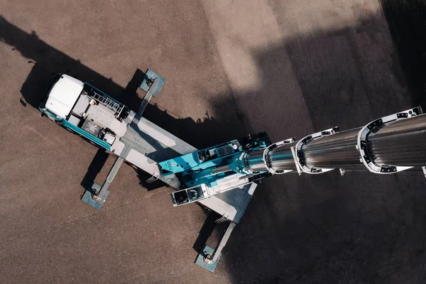 view from the height of the tallest car crane, which is open in the Parking lot near the glass building in the city and ready to work. the highest mobile crane is deployed on the site. the height of the arrow is 80 meters