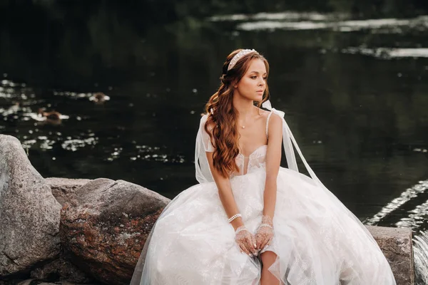 Элегантная Невеста Белом Платье Перчатках Сидит Озера Парке Наслаждаясь Природой — стоковое фото