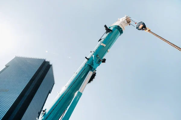 Mecanismo Elevação Guindaste Azul Com Ganchos Perto Edifício Moderno Vidro — Fotografia de Stock