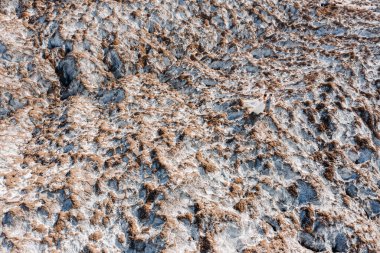 Beyaz tuz dağında poz veren güzel bir çift sevgili. Şık bir gelinlik içinde genç bir kadın ve gri takım elbiseli şık bir adam. Düğün günü konsepti.