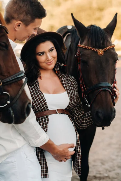 Těhotná Dívka Klobouku Muž Bílém Oblečení Stojí Vedle Koní Blízkosti — Stock fotografie