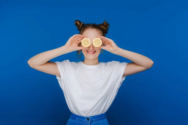 Una Joven Hermosa Niña Pie Sobre Fondo Azul Sostiene Limones — Foto de Stock