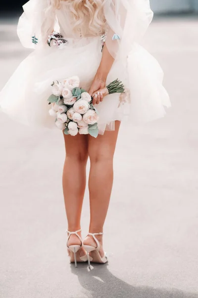 Una Sposa Con Abito Sposa Corto Tiene Bouquet Alle Sue — Foto Stock