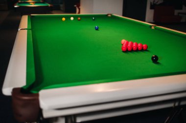 Bilardo toplarını yeşil bir bilardo masasına koymak.