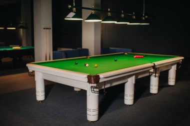 Bilardo toplarını yeşil bir bilardo masasına koymak.