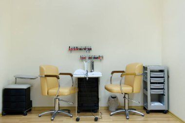 place for a manicure in a beauty salon in bright colors.Two chairs and a table in the nail care room. clipart