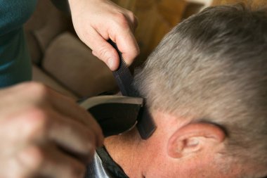 Karantina sırasında ev tıraşı. Makas ve makasla çalış. Kadın eli..