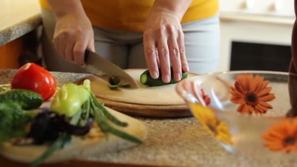 在家煮沙拉 我们在厨房的木制架子上切了根黄瓜 — 图库视频影像