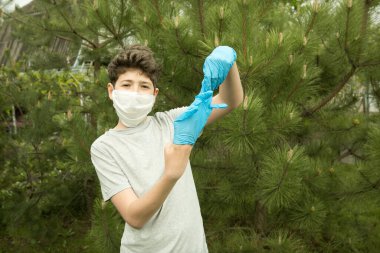 Karantinadan sonra doğadaki genç bir adamın neşesi. Yakında maske ve eldivenlere gerek kalmayacak. Oğlan çıkar ve eldivenleri atar..