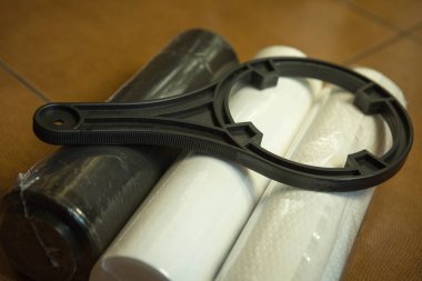 Ev suyu arıtma sistemindeki filtreleri değiştiriyorum. Yeni filtreler 5 mikron, 1 mikron ve kömür yenilenmeye hazır..