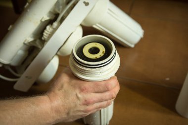 Ev suyu arıtma sistemindeki filtreleri değiştiriyorum. Usta kömür sistemindeki bağırsak filtresini değiştiriyor..