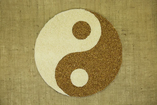 The concept of yin yang. Sign yin yang against the background of burlap. Rice and buckwheat were used.