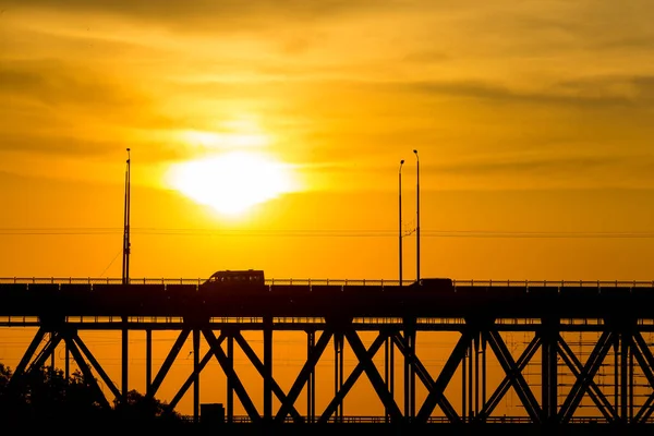 夕暮れ時に川Dnipro上の橋のビュー 夕日は雲の中からとても美しく見えます — ストック写真