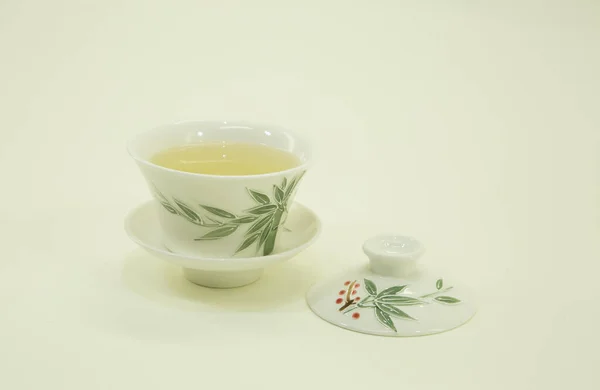 Chinese green tea. Milk Oolong Tea. Green tea in a beautiful traditional oriental cup with saucer. Isolated on a white background.