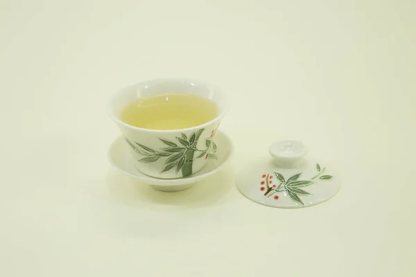 Chinese green tea. Milk Oolong Tea. Green tea in a beautiful traditional oriental cup with saucer. Isolated on a white background.