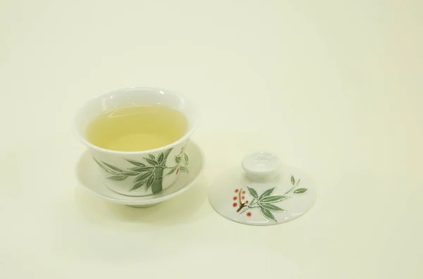 Chinese green tea. Milk Oolong Tea. Green tea in a beautiful traditional oriental cup with saucer. Isolated on a white background.