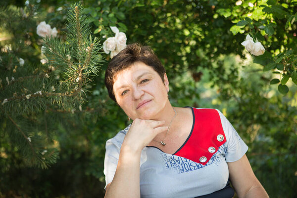 Picture of a middle-aged woman. Concept of emotions. Woman is happy to have rest outdoors after quarantine is relaxed.