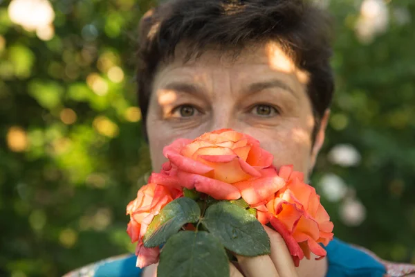 Picture of a middle-aged woman. Protection against coronavirus can also be beautiful. A woman has decorated the medical mask with roses.