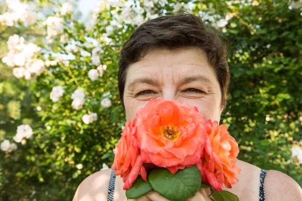 Picture of a middle-aged woman. Protection against coronavirus can also be beautiful. A woman has decorated the medical mask with roses.