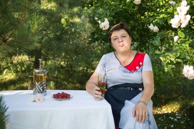 Orta yaşlı bir kadının fotoğrafı. Duygu kavramı. Karantina sona erdikten sonra kadın dışarıda dinlenmekten mutlu olur..