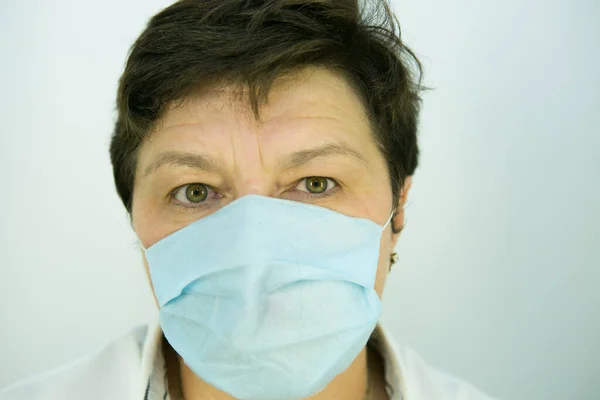 Coronavirus epidemic. Doctor warns of danger in the face of a pandemic. Portrait of a female doctor in a medical mask.