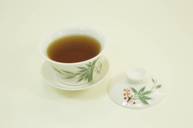 Çin çayı. Altın Kaş Çayı. Geleneksel çay fincanı ve çay tabağı. Beyaz arka planda beyaz bir kasede izole edilmiş..