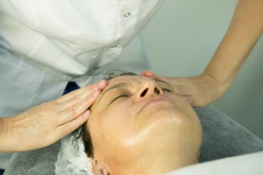 Güzellik uzmanına bir ziyaret. Prosedür-karboks terapisi. Doktor kozmetik uzmanı ameliyattan sonra hastaya yüz masajı yapıyor..