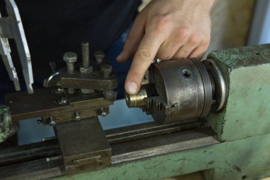 Torna tezgahında çalışıyorum. Makine iş için hazır. Sihirbaz ayarların doğru olup olmadığını kontrol eder.