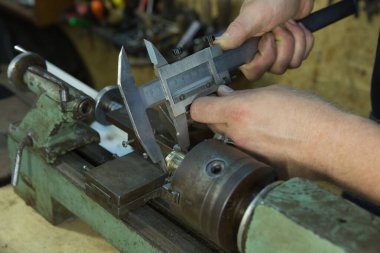 Torna tezgahında çalışıyorum. Makine iş için hazır. Sihirbaz ayarların doğru olup olmadığını kontrol eder.