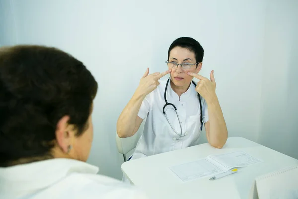 A visit to a beautician. The doctor tells the patient about the need for facial skin care.