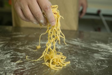 Sağlıklı gıda konsepti. Doğal yumurtalı erişte yapma süreci. Şefin elleri erişteleri kurusun diye hazırlıyor..