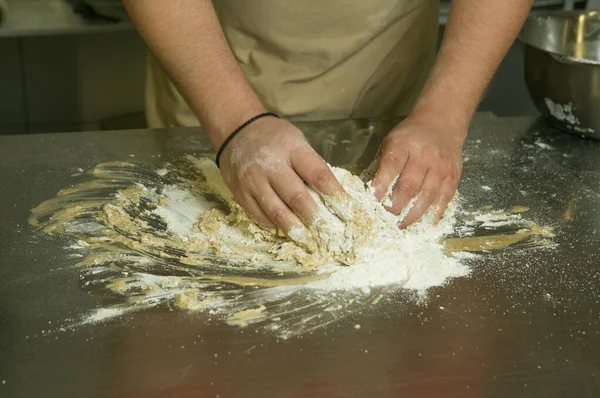 パンを作る過程 シェフは手作りで生地をこねる シェフの手は生地のためのすべての成分を混ぜます — ストック写真