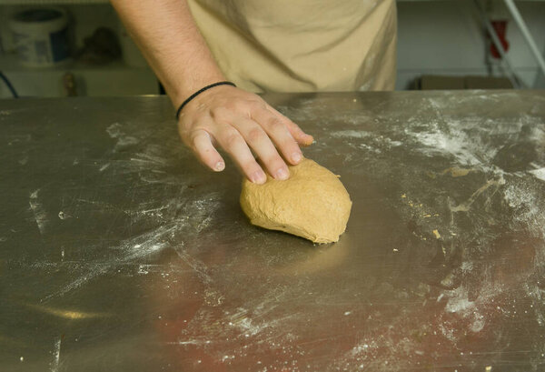The process of making bread. The chef kneads the dough by hand.