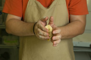 Meyveli tatlı hamur işleri için üretim süreci. Şef pişirme hamurunu elle yapar. Adam malzemeleri ekler ve karıştırır..