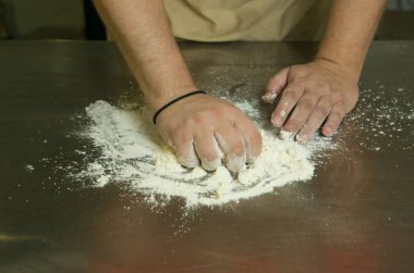 Meyveli tatlı hamur işleri için üretim süreci. Şef pişirme hamurunu elle yapar. Adam malzemeleri ekler ve karıştırır..