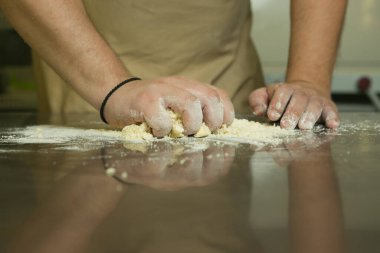 Meyveli tatlı hamur işleri için üretim süreci. Şef pişirme hamurunu elle yapar. Adam malzemeleri ekler ve karıştırır..