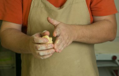 Meyveli tatlı hamur işleri için üretim süreci. Şef pişirme hamurunu elle yapar. Adam malzemeleri ekler ve karıştırır..
