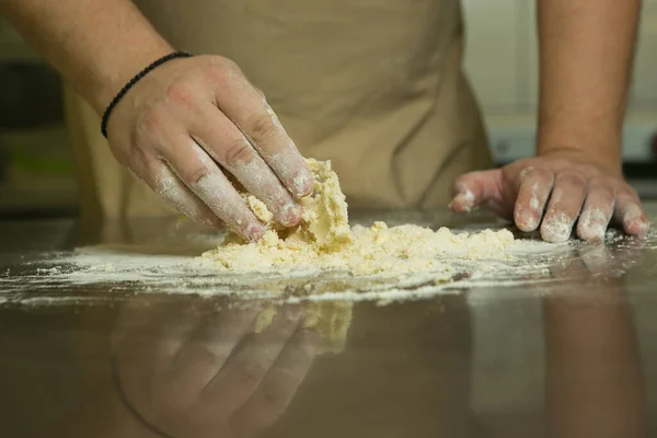 果物と甘いペストリーの生産プロセス シェフはベーキング生地を手作業で作る 男は材料を加え混ぜ — ストック写真