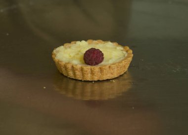 Meyveli tatlı hamur işleri için üretim süreci. Taze pişmiş turtalar. Aşçı, ahududuları tart ile hazırlar..