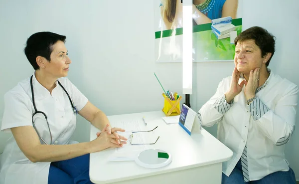 A visit to a beautician. The doctor tells the patient about the need for facial skin care.