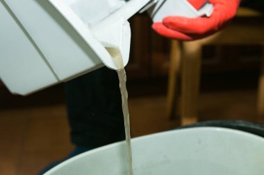 Bir odayı elektrikli süpürgeyle ve su filtresiyle temizleme işlemi. Temizlikten sonra kirli su. Konteynırdan süzülen su.