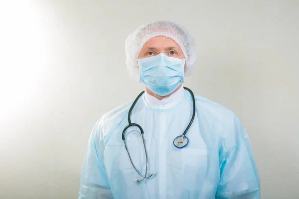 Portrait of a doctor man in a medical mask. There is a stethoscope on the doctor\'s neck. During a pandemic, remedies are essential. Isolated on white background.