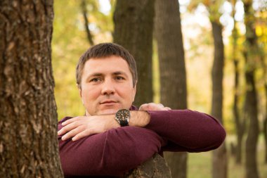 Orta yaşlı bir adam sonbahar ormanında dinleniyor. Portre.