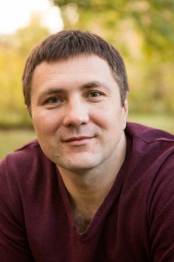 Orta yaşlı bir adam sonbahar ormanında dinleniyor. Portre.