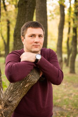 Orta yaşlı bir adam sonbahar ormanında dinleniyor. Portre.